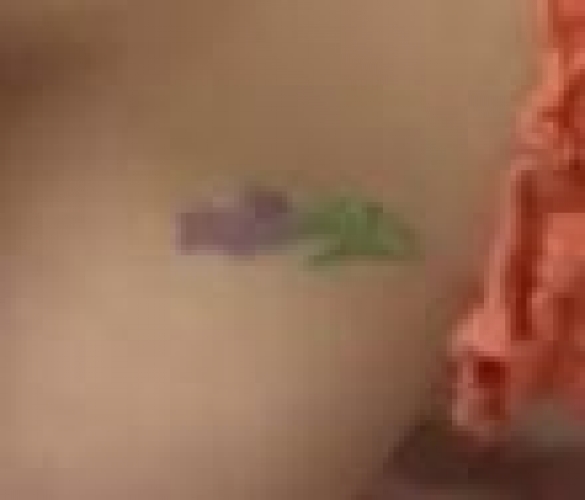 Colored tattoo (flower) on left side of left breast